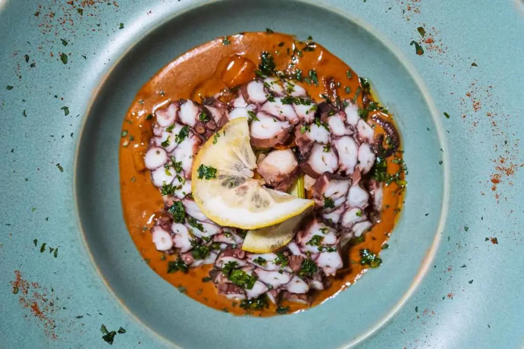 Thin sliced octopus carpaccio drizzled with citrus vinaigrette at KAIO Beach Front Restaurant.