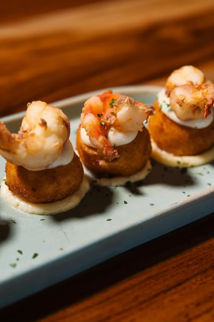 Crispy golden shrimp croquettes garnished with prawns and aioli at KAIO Beach Front Restaurant.